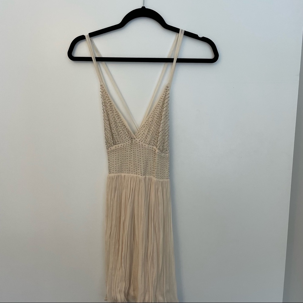 Free People Cream sparkly mini dress with a strappy back!
Size: 2 Never worn!